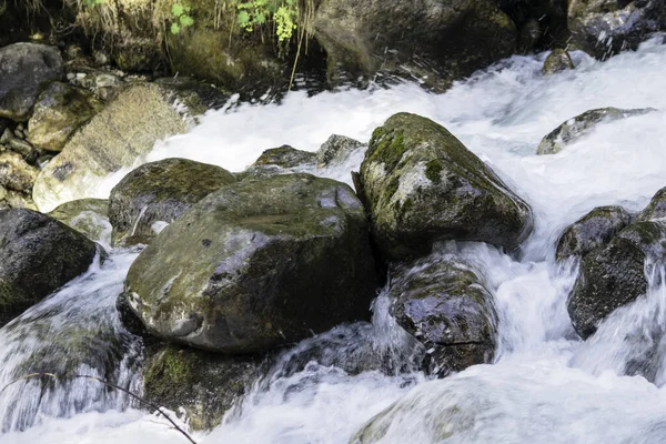 L'acqua del burrascoso fiume di montagna che scorre tra sassi e massi — Foto Stock