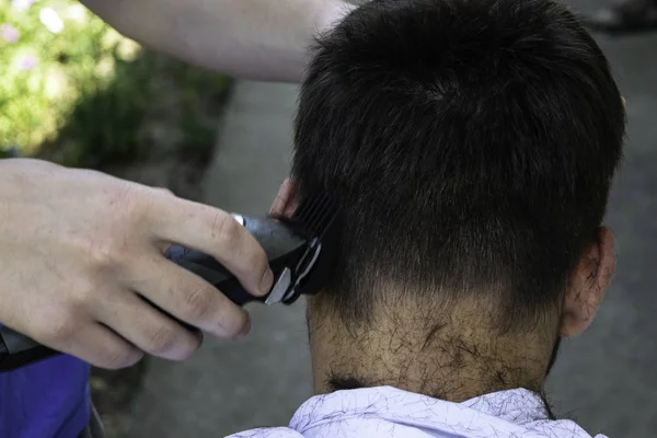 Un peluquero corta al tipo con un cortaplumas — Foto de Stock