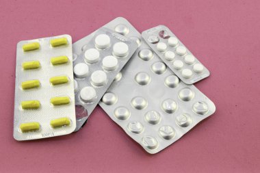 Pembe kadife arka planda dört paket hap.