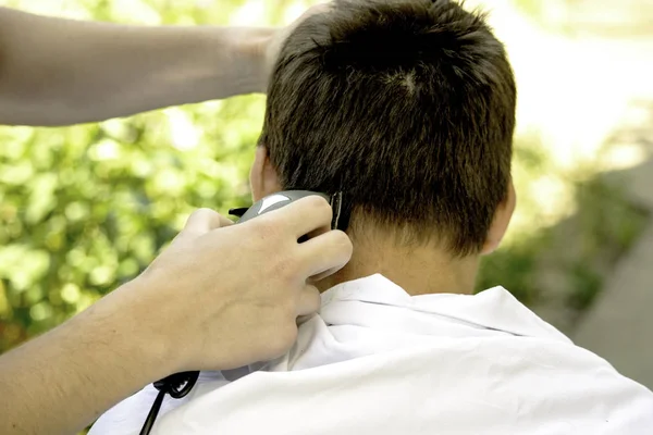 Un peluquero corta al tipo con un cortaplumas — Foto de Stock