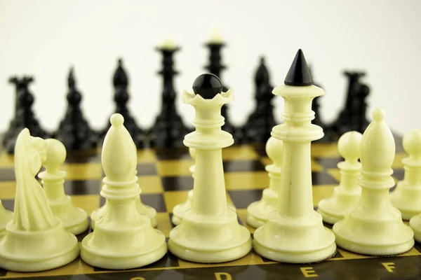 Piezas de ajedrez en blanco y negro de pie en un tablero de ajedrez antes del inicio de una partida , — Foto de Stock