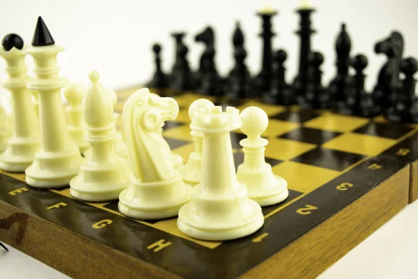 Piezas de ajedrez en blanco y negro de pie en un tablero de ajedrez antes del inicio de la partida — Foto de Stock