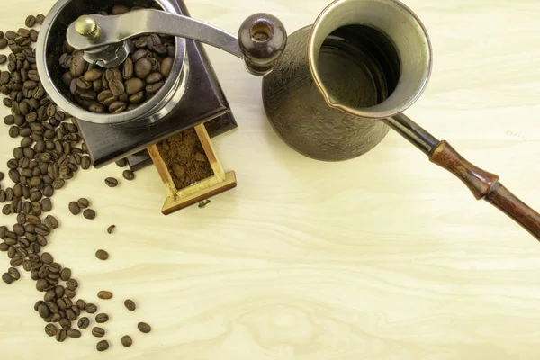 Coffee beans, manual coffee grinder and a Turk for brewing coffee are on the table — Stock Photo, Image