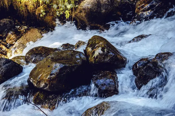 The water of the stormy mountain river flowing among stones and boulders — Stock Photo, Image