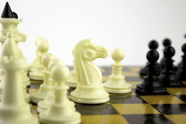 Piezas de ajedrez blanco de pie en un tablero de ajedrez durante una partida de ajedrez, se centran en el centro del tablero — Foto de Stock