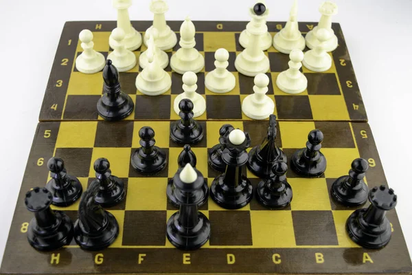 Vita schackpjäser står på ett schackbräde under ett parti schack, ovanifrån — Stockfoto