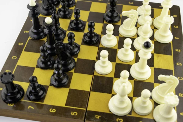 Vita schackpjäser står på ett schackbräde under ett parti schack, ovanifrån — Stockfoto