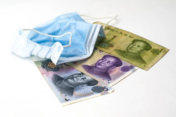 Het concept coronovirus en de economie van China Chinese yuan geld liggen in de buurt van medische hygiëne masker — Stockfoto