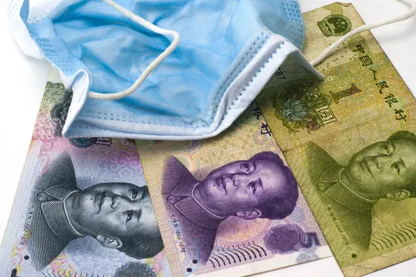 Het concept coronovirus en de economie van China Chinese yuan geld liggen in de buurt van medische hygiëne masker close-up — Stockfoto