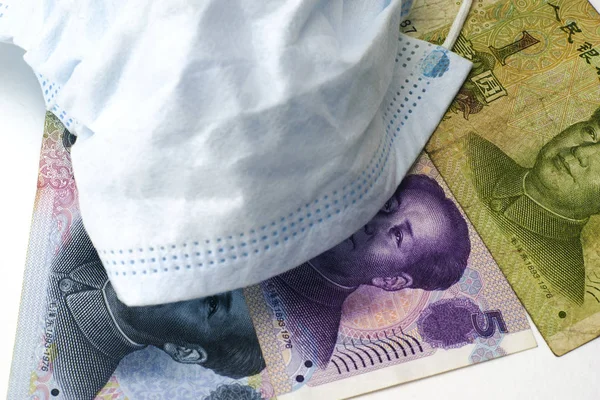 Koncept coronovirus a ekonomika čínského jüanu peníze leží v blízkosti lékařské hygieny masky close-up — Stock fotografie