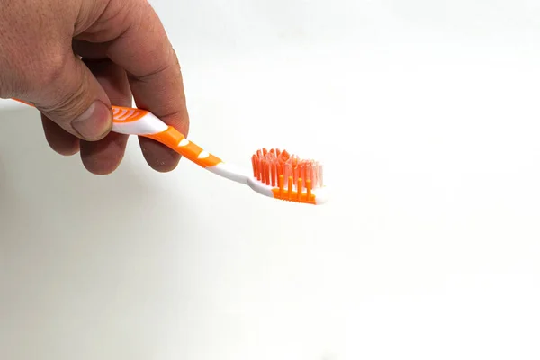 Escova de dentes em uma mão de homem no fundo branco — Fotografia de Stock