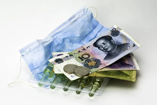 Concept coronovirus and Chinese economy, Chinese yuan money, hygiene mask and ampoules with medicine on the white background — Stock fotografie