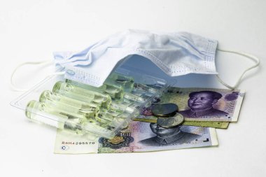 concept coronovirus and Chinese economy, Chinese yuan money, hygiene mask and ampoules with medicine on the white background