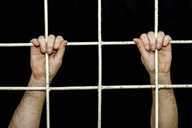 Karantina döneminde sınırlama kavramı insan elleri demir parmaklıklara tutunur.