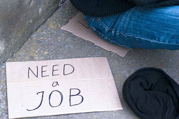 找工作 坐在一个失业的人旁边 是一顶施舍的帽子和一个刻有 需要工作 字样的硬纸板 — 图库照片