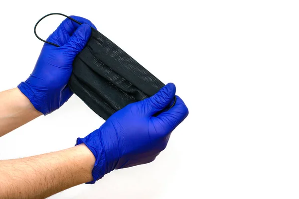 Hände Blauen Medizinhandschuhen Halten Eine Schwarze Hygienemaske Auf Weißem Hintergrund — Stockfoto