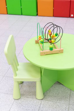 Renkli çocuk koltuğu ve oyuncaklarla dolu çocuk masası