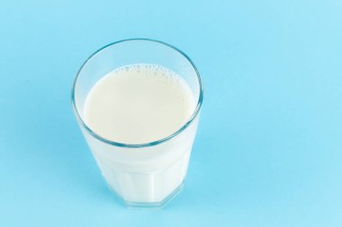 Mavi arka planda bir bardak taze süt, boşluğu kopyala