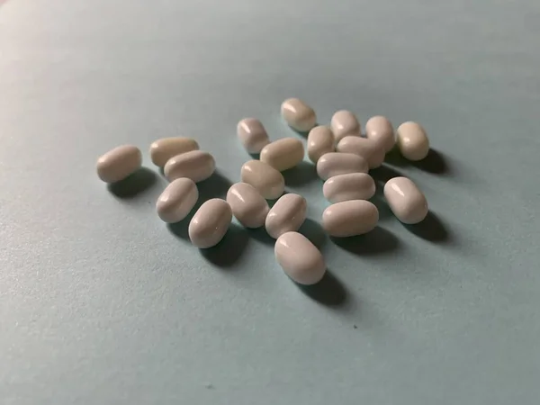 Witte medische pillen of snoep op lichtblauwe achtergrond. — Stockfoto