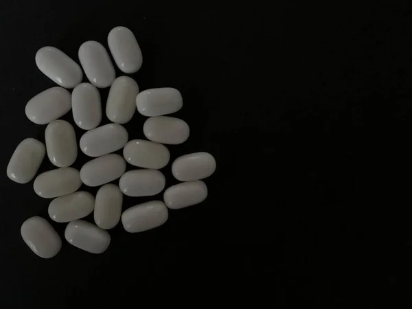 Tabletki i tabletki na ciemnym tle — Zdjęcie stockowe