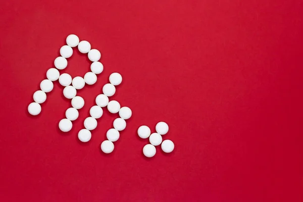 Factor Rh positivo. Rh inscripción hecha de píldoras blancas sobre un fondo rojo con espacio de copia . — Foto de Stock