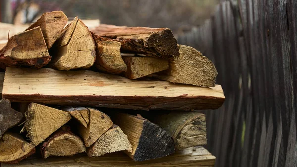 Una pequeña parte de la pila de madera en la cerca de madera gris tejida en t — Foto de Stock