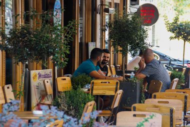 Tiran, Arnavutluk - 20 Ağustos 2017: Arnavutluk 'un başkenti Tiran' da masalarda ve garsonların oturduğu güzel ve rahat bir kafe. Arnavut mutfağı