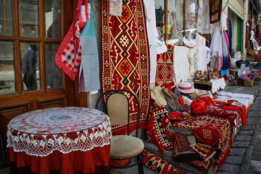 Cirokastra, Arnavutluk - 12 Ağustos 2016: Kent merkezindeki bir hediyelik eşya dükkanında geleneksel el yapımı Arnavut halıları ve masa örtüleri.