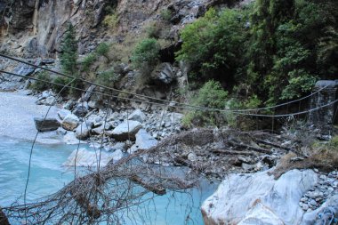 Nepal 'deki Himalaya dağlarının muhteşem manzarası. Dünyanın en yüksek yaya geçidi. Torong La, Annapurna 'nın etrafında bir yürüyüş çemberinde. Temiz içme suyuyla dağ nehri ve eski yıkılmış bir köprü..