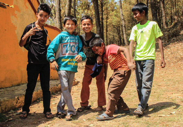 KATHMANDU, NEPAL - APRIL 8, 2014: Children boys play in the courtyard in the village suburb of Kathmandu and laughing hug each other and posing for the camera. Children of Nepal.