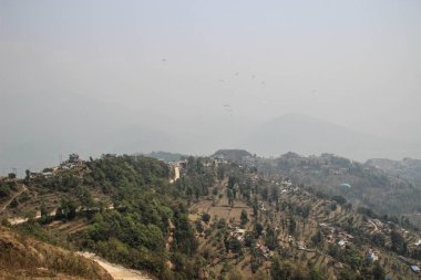 Himalayalar, Pokhara 'daki Pheva Gölü' ne giden bir paraglider. Pirinç tarlaları, dağlar ve küçük evler. 