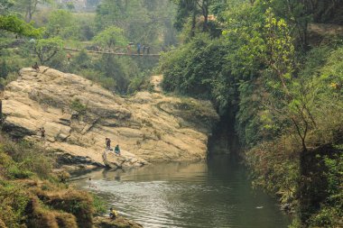Pokhara, Nepal - 8 Nisan 2014: Nepal, Pokhara 'nın merkezindeki taşların arasında bir dağ nehrinde giysileri yıkayan ve yıkayan bir kalabalık.