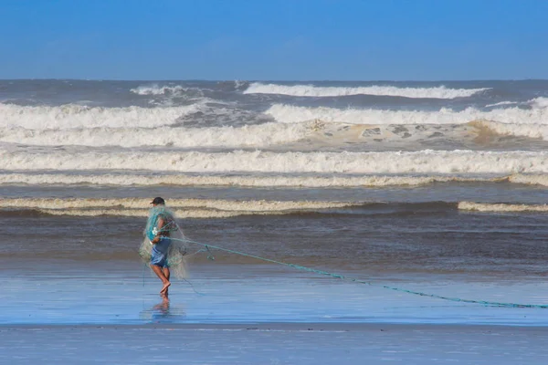 Místní brazilští rybáři ryby sítě mezi velkými vlnami na shor — Stock fotografie
