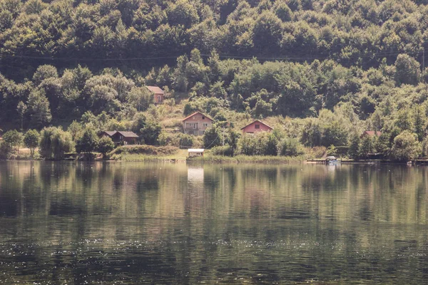 Calm beautiful lake surrounded by forests and rural houses. — Stock Photo, Image