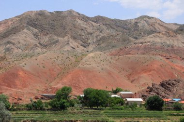 Sıcak bir yerde kayalar ve jeolojik oluşumlarla çöl manzarası.