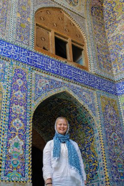 Meşhur Jameh Camii 'nin arka planında genç bir turist kız. 