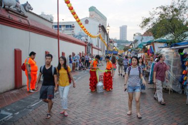 SINGAPORE, SINGAPORE - 10 Nisan 2016: Sokak sanatçıları ejderha kostümleri ve müzikleriyle gösteri yapmaya hazırlanıyorlar.