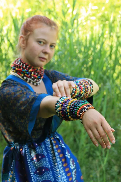 白种人的长发姑娘 红头发 穿着传统衣服 装饰着许多木制的非洲项链 — 图库照片