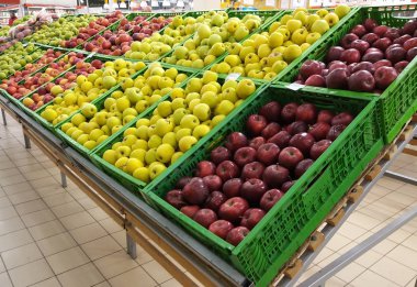 Süpermarketin vitrininde kırmızı ve sarı elmalar