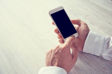 Akıllı telefon kullanan erkek elleri.