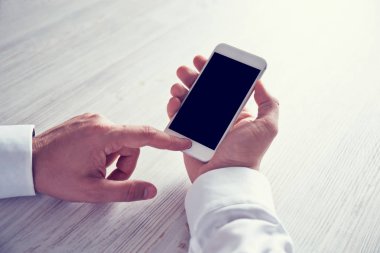 Akıllı telefon kullanan erkek elleri.
