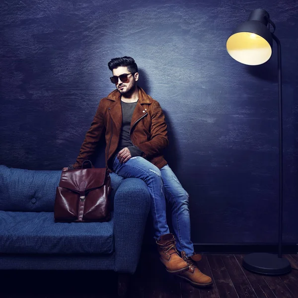 Young man sitting on sofa — Stock Photo, Image