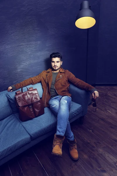 Handsome man sitting on sofa — Stock Photo, Image