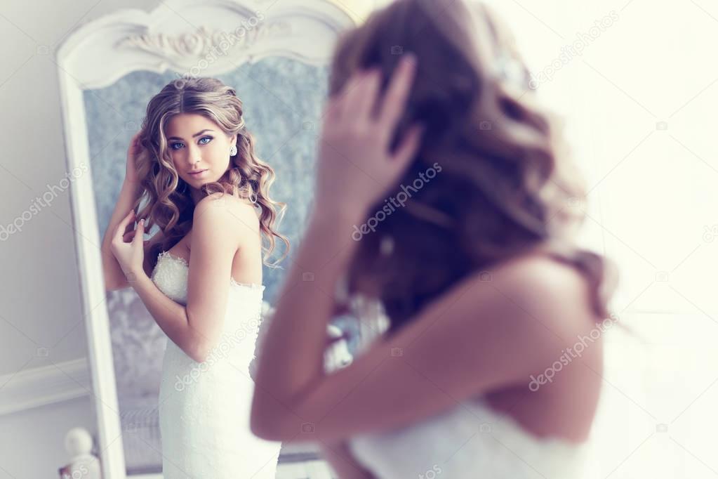 beautiful bride looking in mirror 