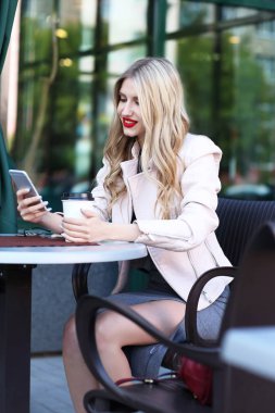 sarışın kadın telefonu kullanarak