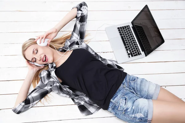 Woman in headphones lying on floor — Stock Photo, Image