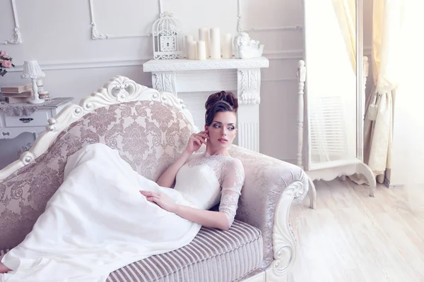 Bride lying in antique couch — Stock Photo, Image