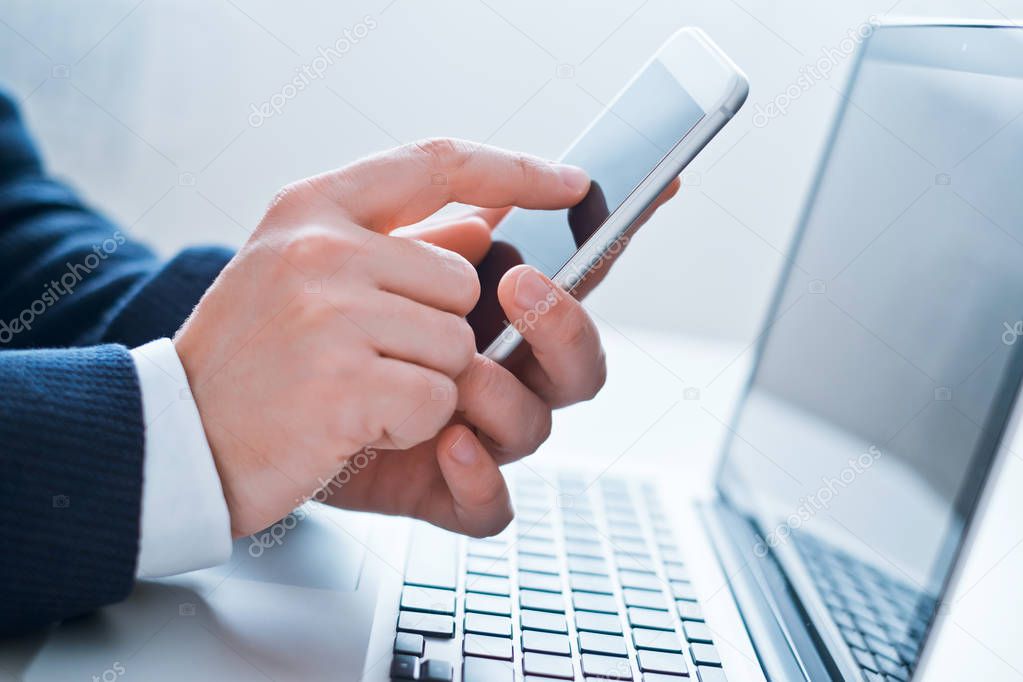 Businessman using laptop and phone