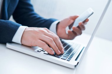 dizüstü bilgisayar ve telefon kullanarak iş adamı