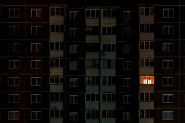 light in a single window. Flat night panorama of multicolor light in windows of multistory buildings. life in big city clipart